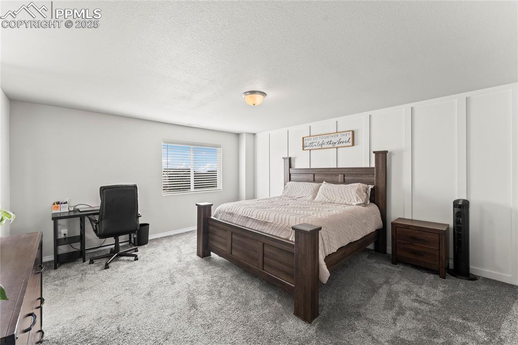 Image 10 of 40: Bedroom with carpet flooring, a textured ceiling, an office area, and a dec