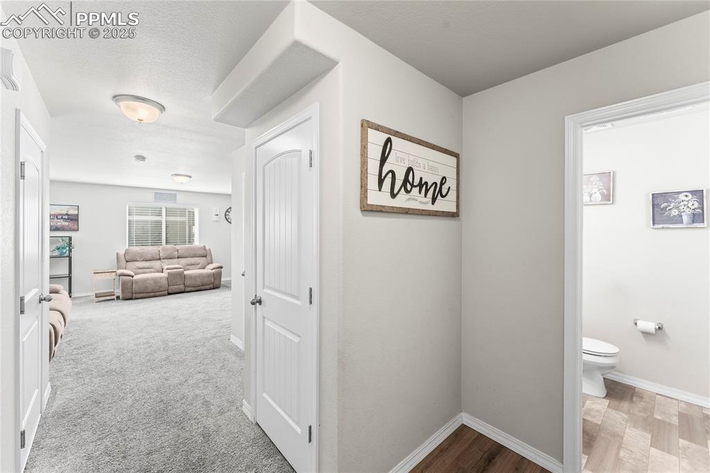Image 14 of 40: Hallway with a textured ceiling and light wood-style flooring