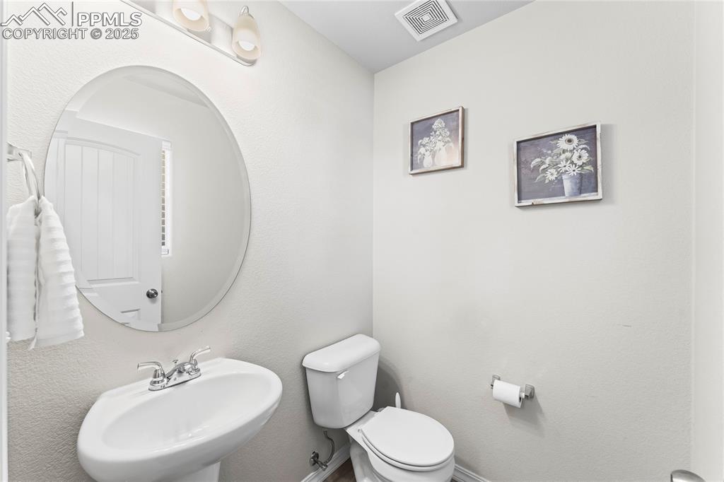 Image 15 of 40: Half bath with a sink and a textured wall