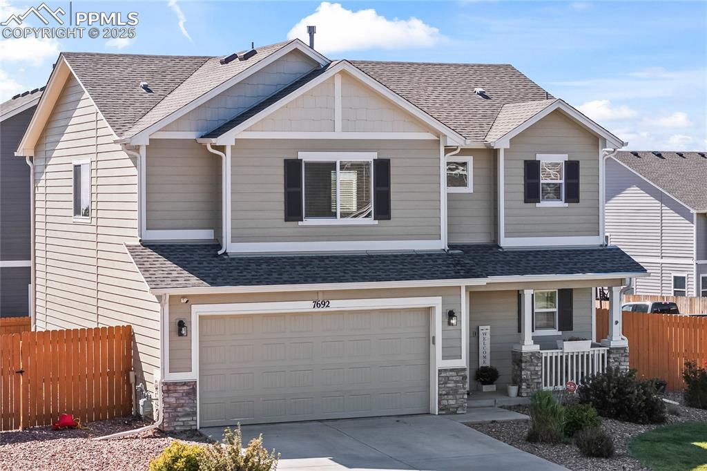 Image 2 of 40: Craftsman house with a porch, stone siding, a shingled roof, and concrete d
