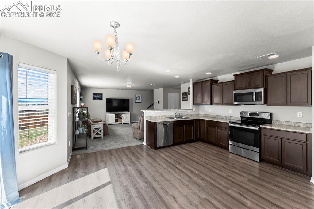 Image 22 of 40: Kitchen with appliances with stainless steel finishes, open floor plan, lig