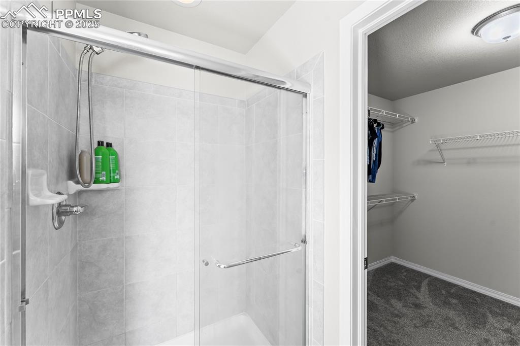 Image 26 of 40: Bathroom with a shower stall and a walk in closet