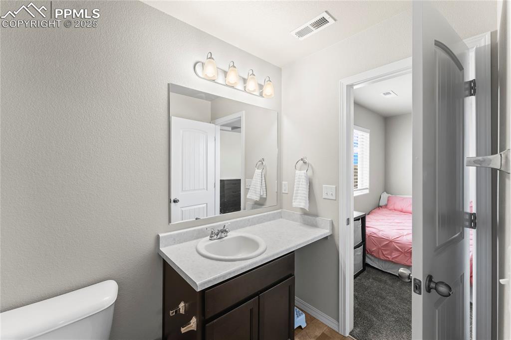 Image 29 of 40: Ensuite bathroom with vanity and a textured wall