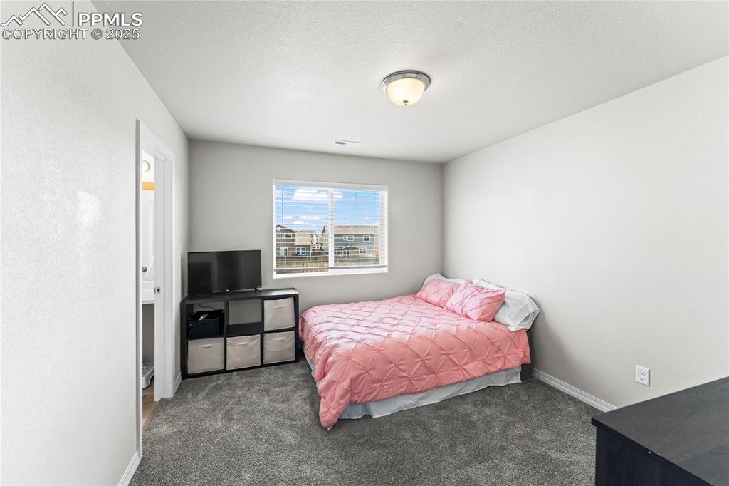 Image 30 of 40: Carpeted bedroom with baseboards and a textured ceiling