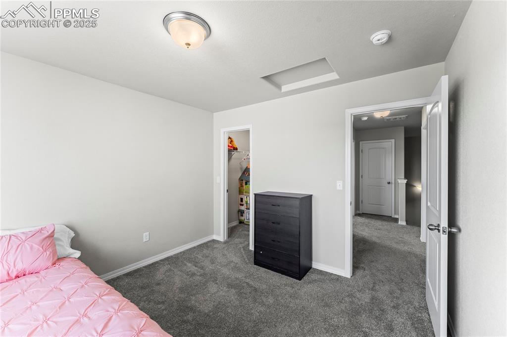 Image 32 of 40: Bedroom featuring attic access, carpet flooring, and a spacious closet