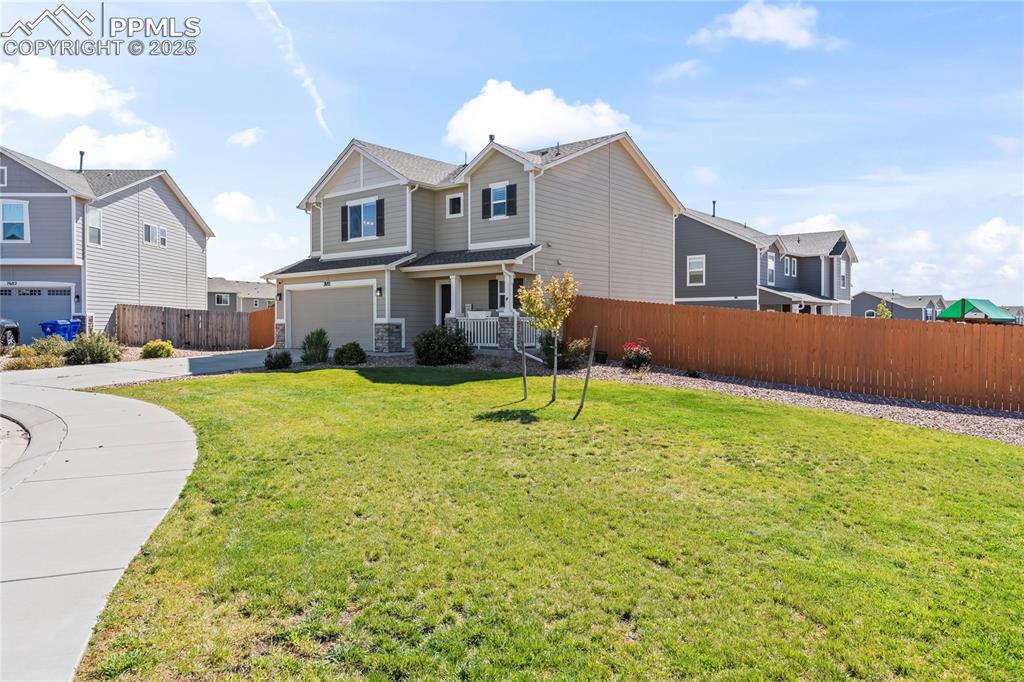 Image 4 of 40: View of front of home featuring covered porch, a garage, and a residential 