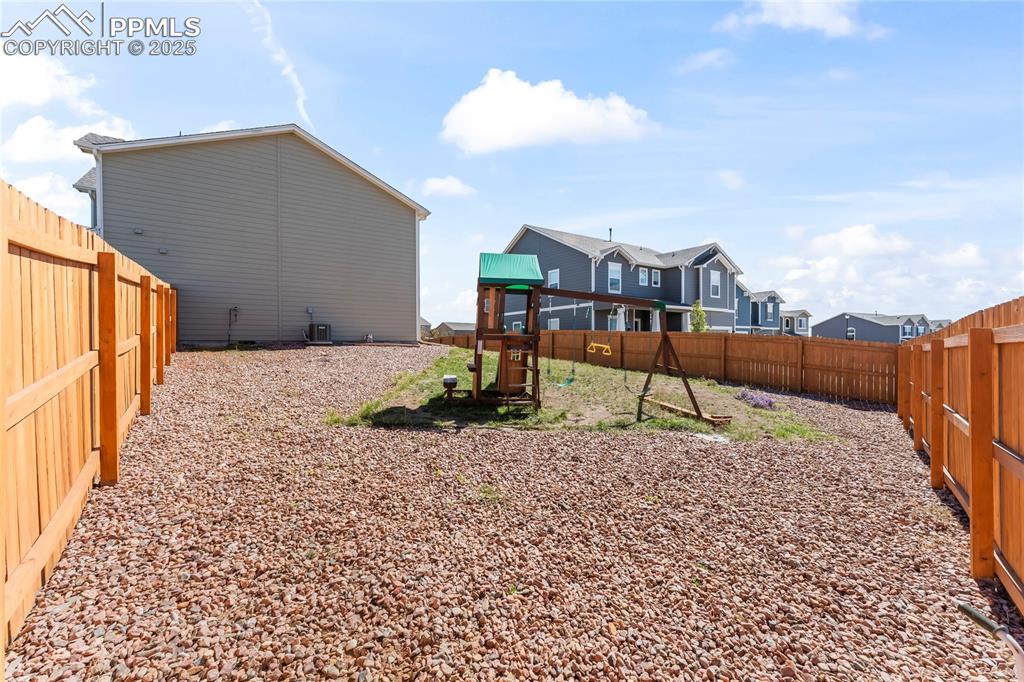 Image 5 of 40: Fenced backyard featuring a playground and a residential view