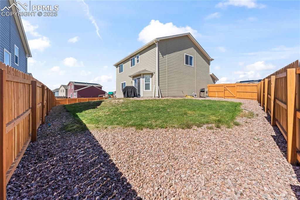 Image 6 of 40: Rear view of house with a fenced backyard