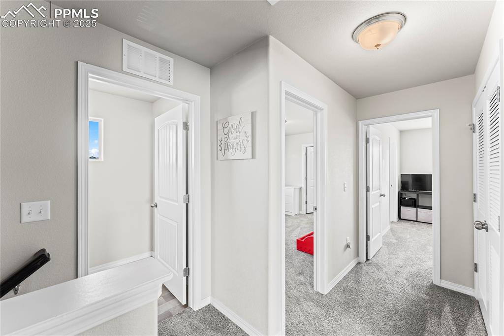 Image 8 of 40: Hallway featuring light carpet and baseboards