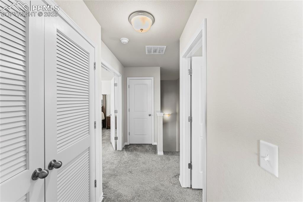 Image 9 of 40: Hallway featuring light carpet and baseboards