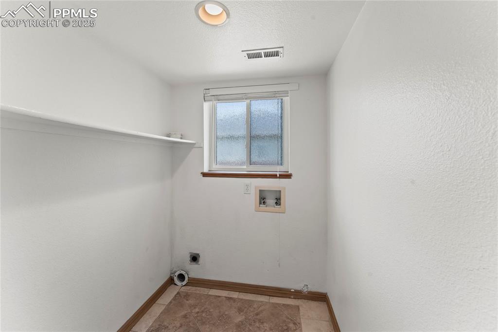 Image 19 of 42: Laundry room with hookup for a washing machine, light tile patterned floors