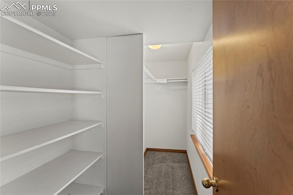 Image 25 of 42: Spacious closet with carpet floors