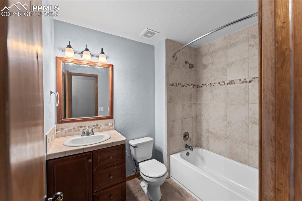Image 28 of 42: Full bath featuring vanity, shower / bath combination, tile patterned floor