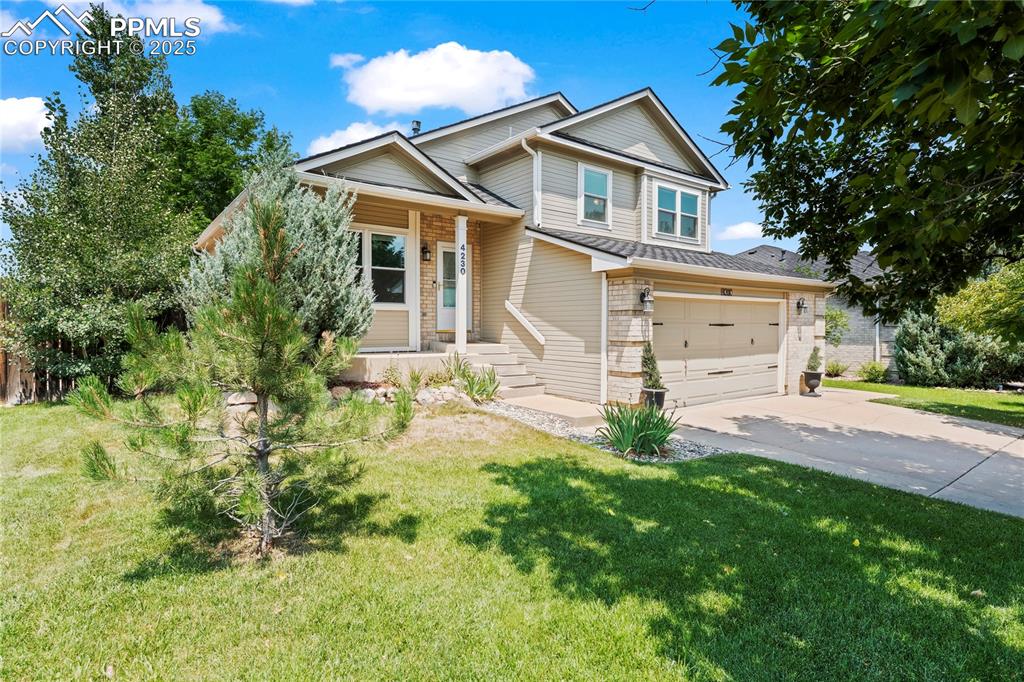 Image 3 of 42: View of front of property featuring driveway, a front lawn, and an attached