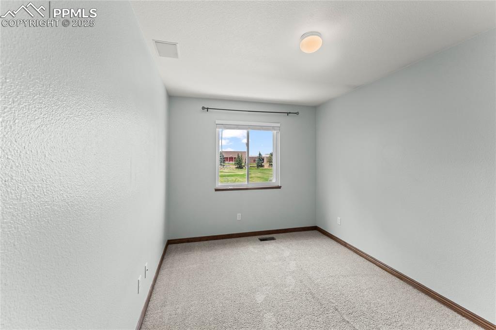 Image 32 of 42: Carpeted spare room featuring a textured wall and a textured ceiling