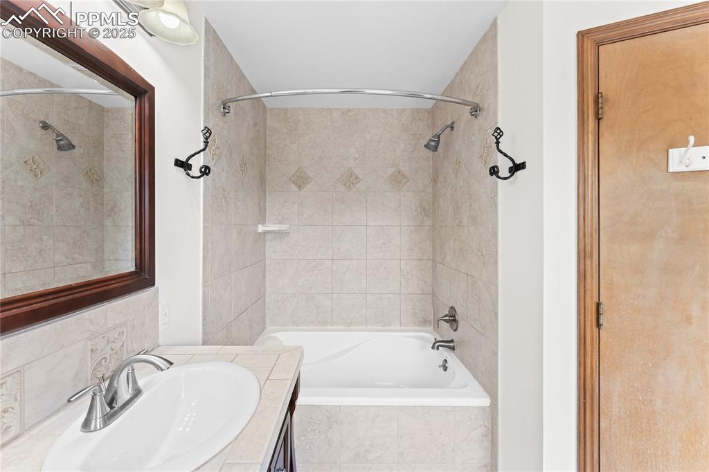 Image 38 of 42: Full bathroom with vanity and tiled shower / bath combo