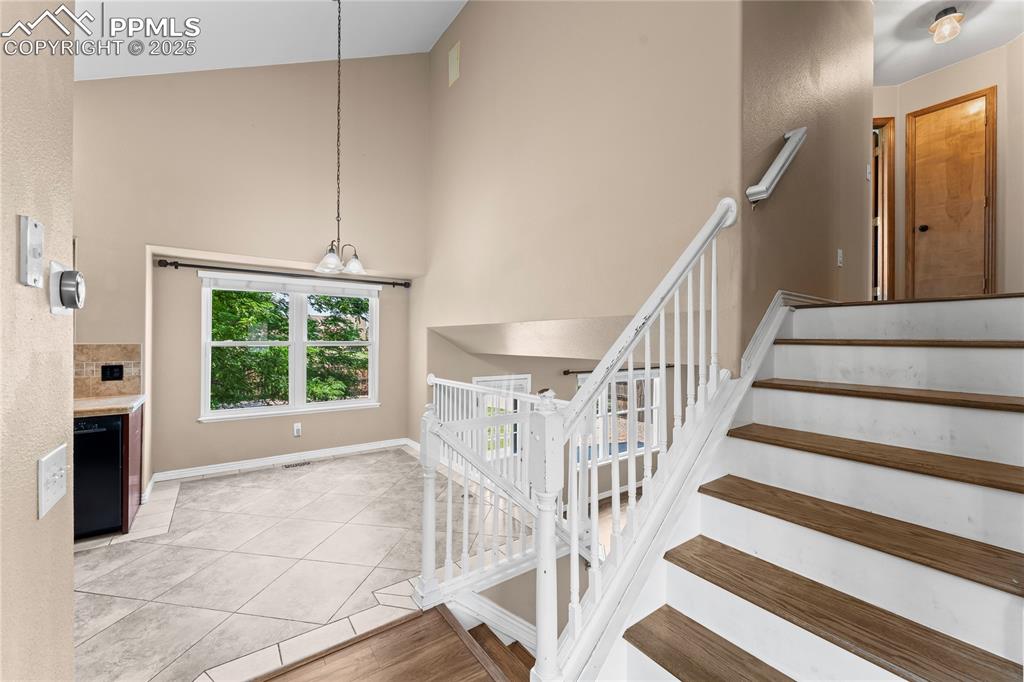 Image 8 of 42: Stairs with a towering ceiling and tile patterned floors