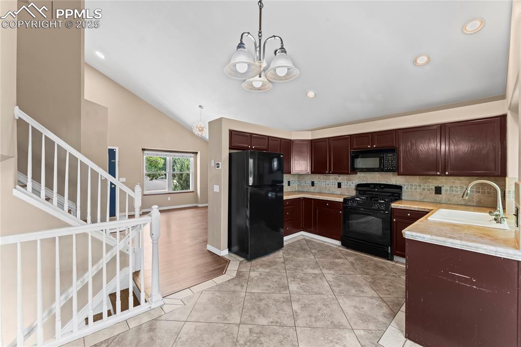 Image 9 of 42: Kitchen featuring black appliances, tasteful backsplash, light countertops,