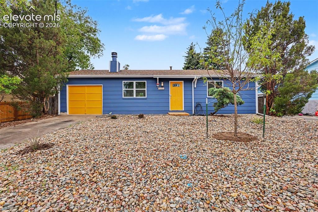 Image 10 of 43: Single-story residence featuring a blue exterior with a contrasting yellow 