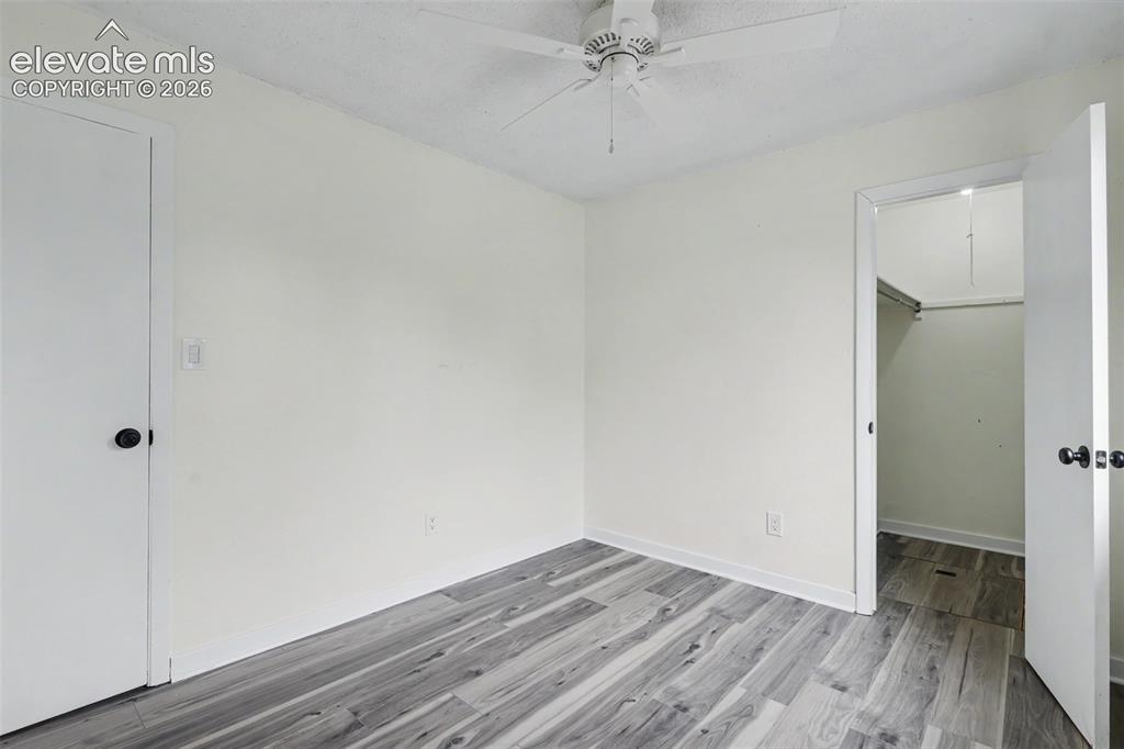 Image 36 of 43: Room featuring wood-finish flooring, a ceiling fan, and a closet with a han