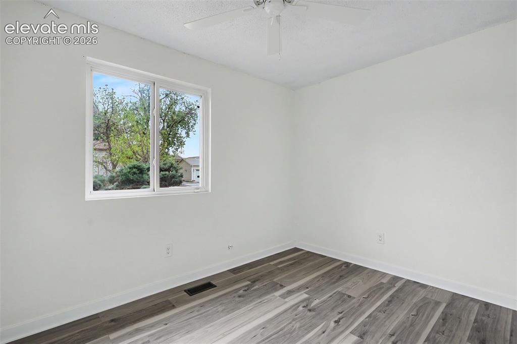 Image 38 of 43: Bright room featuring a window with exterior landscaping, wood-finish floor