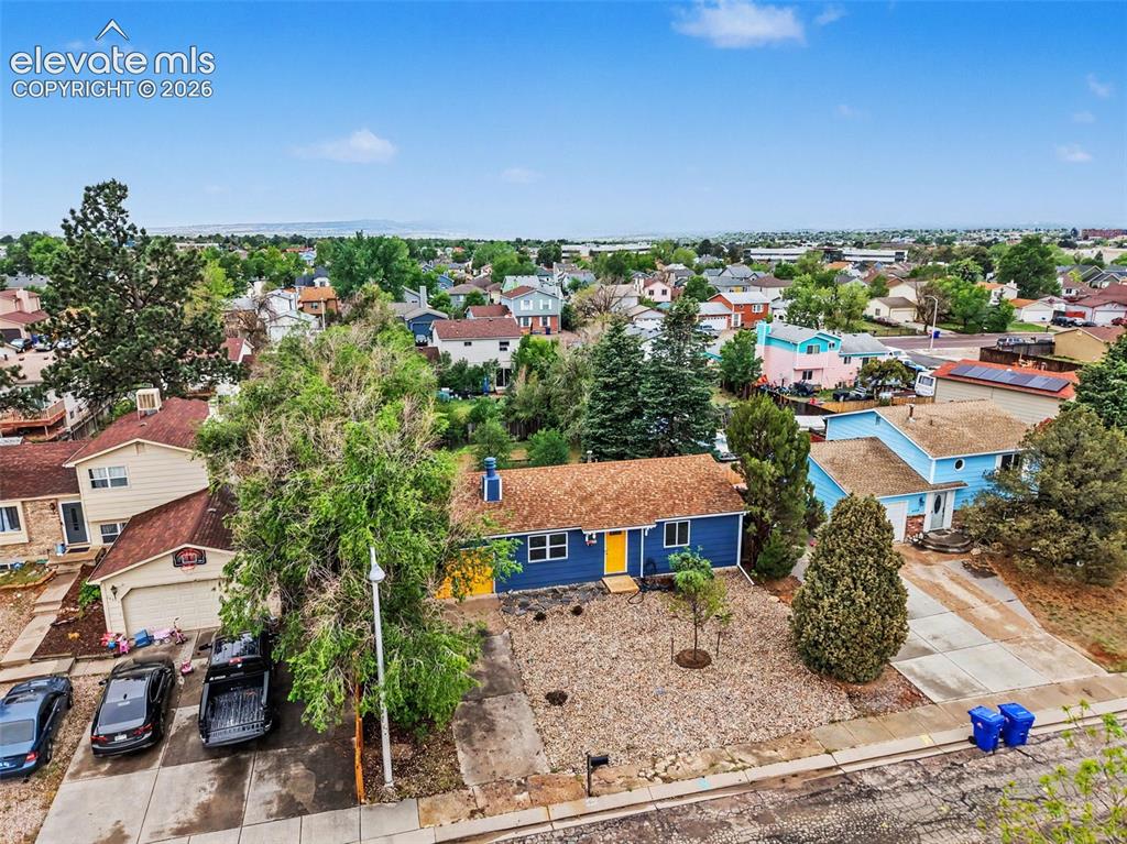Image 4 of 43: Single-story residence featuring a blue exterior and a prominent yellow fro
