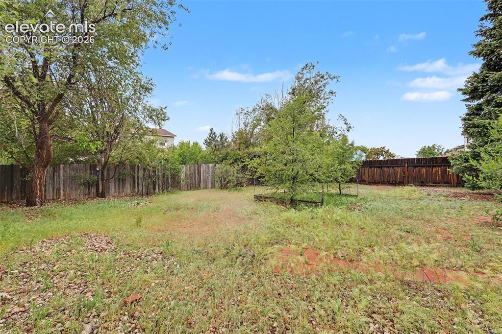 Image 41 of 43: Expansive outdoor space featuring a large grassy area, mature trees, and a 