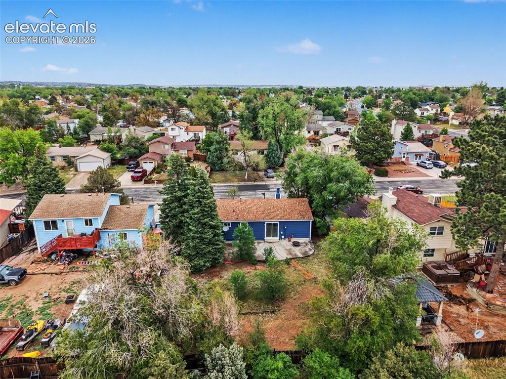 Image 5 of 43: Aerial perspective of a blue-sided residence with a brown roof