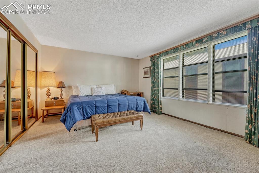 Image 22 of 32: Bedroom featuring light carpet, a closet, and a textured ceiling