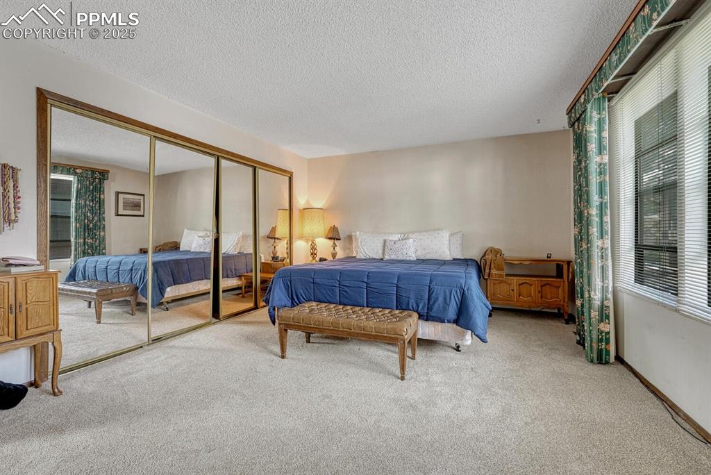 Image 23 of 46: Bedroom featuring a closet, carpet, and a textured ceiling
