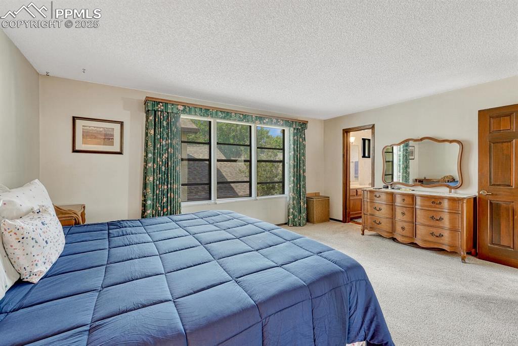 Image 24 of 46: Carpeted bedroom featuring a textured ceiling