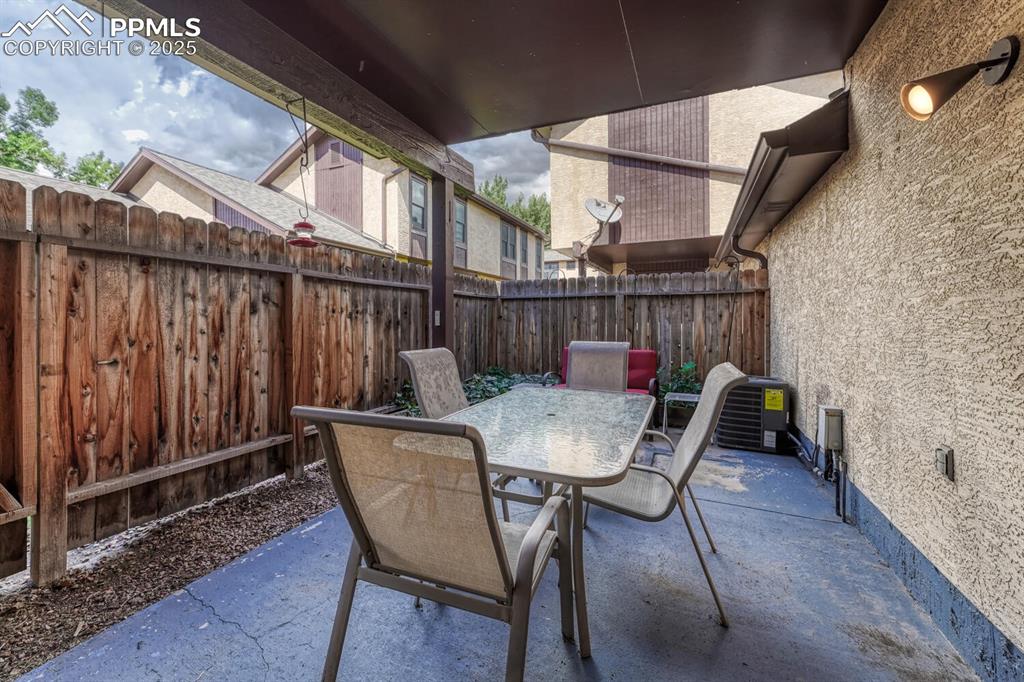 Image 33 of 46: This securely fenced backyard presents a designated patio area perfect for 