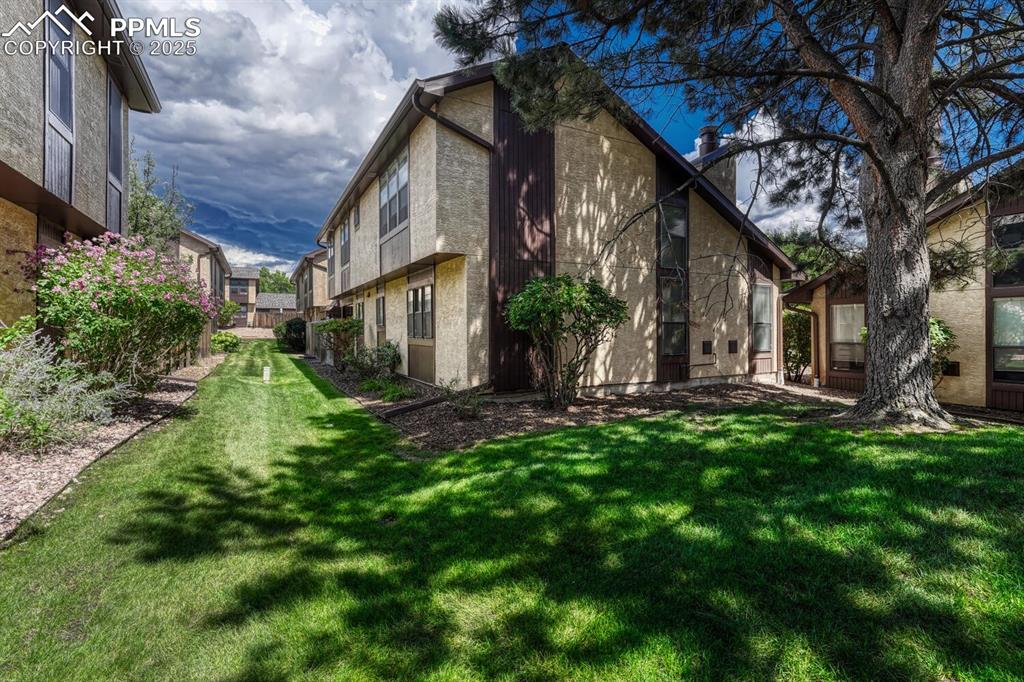 Image 39 of 46: View of side of property featuring a lawn and a chimney