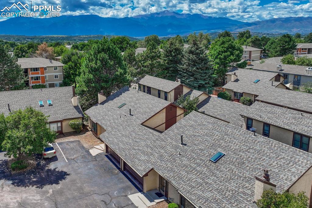 Image 42 of 46: Aerial view of residential area featuring a mountainous background