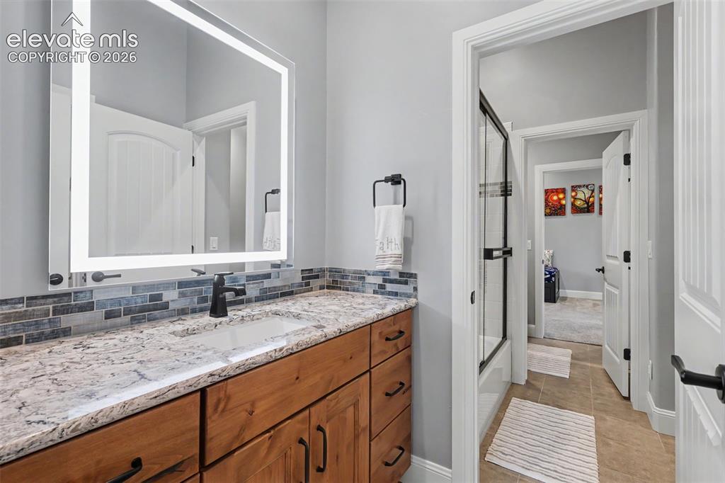 Image 43 of 48: Bathroom vanity featuring a granite countertop, integrated sink, matte blac