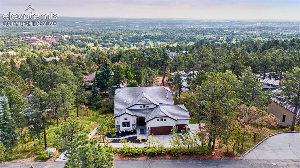 Image 7 of 48: Modern architecture with a multi-gabled roofline and stone and stucco exter