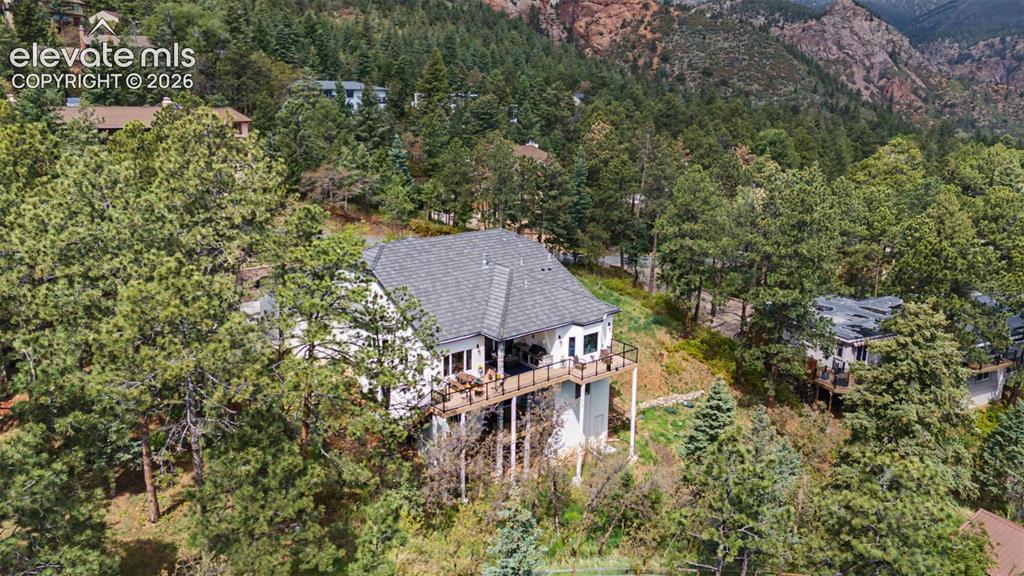 Image 8 of 48: White-sided residence with dark gray roofing