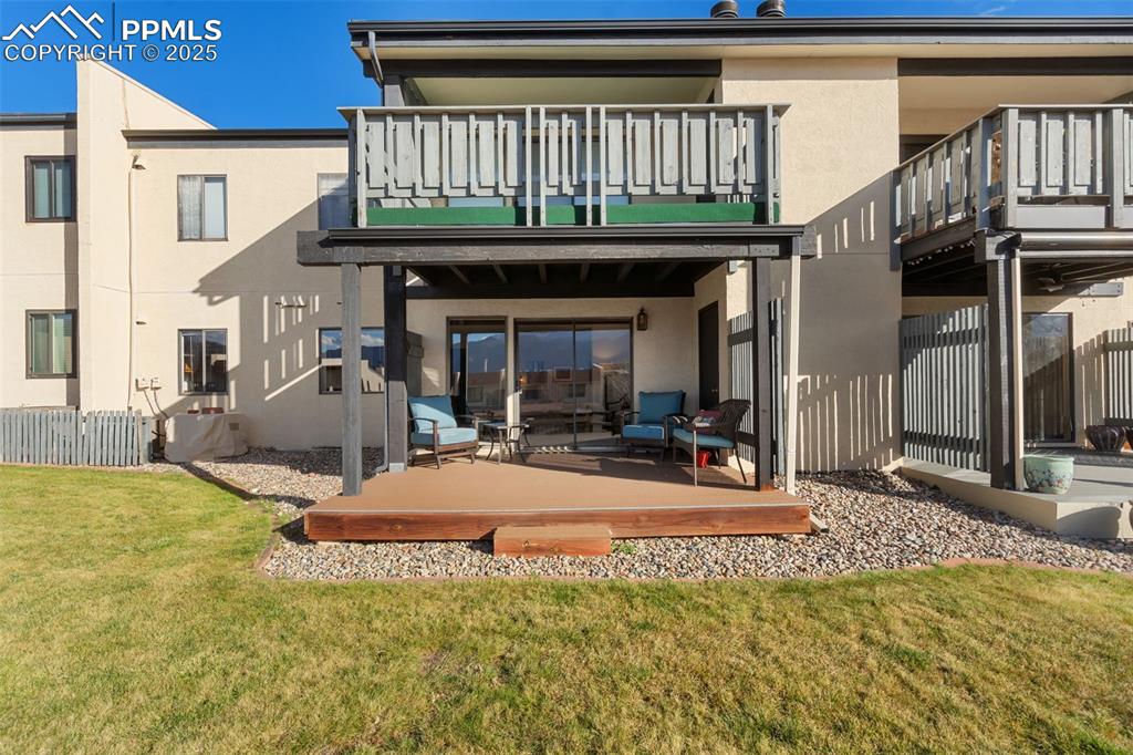 Image 28 of 28: The covered deck leads to a lovely grassy area.