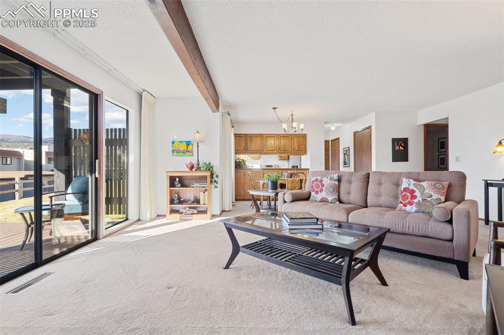 Image 9 of 28: The living room adjoins the dining area and provides a view into the kitche