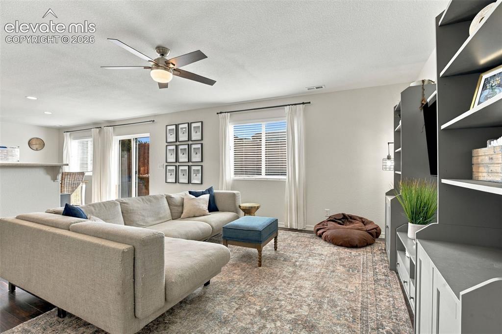 Image 10 of 48: Wood-finish flooring, recessed lighting, and a ceiling fan with integrated 