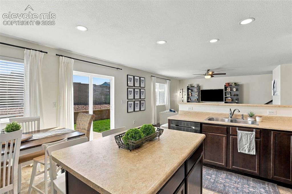Image 18 of 48: Kitchen featuring dark wood-finish cabinetry, a double basin stainless stee