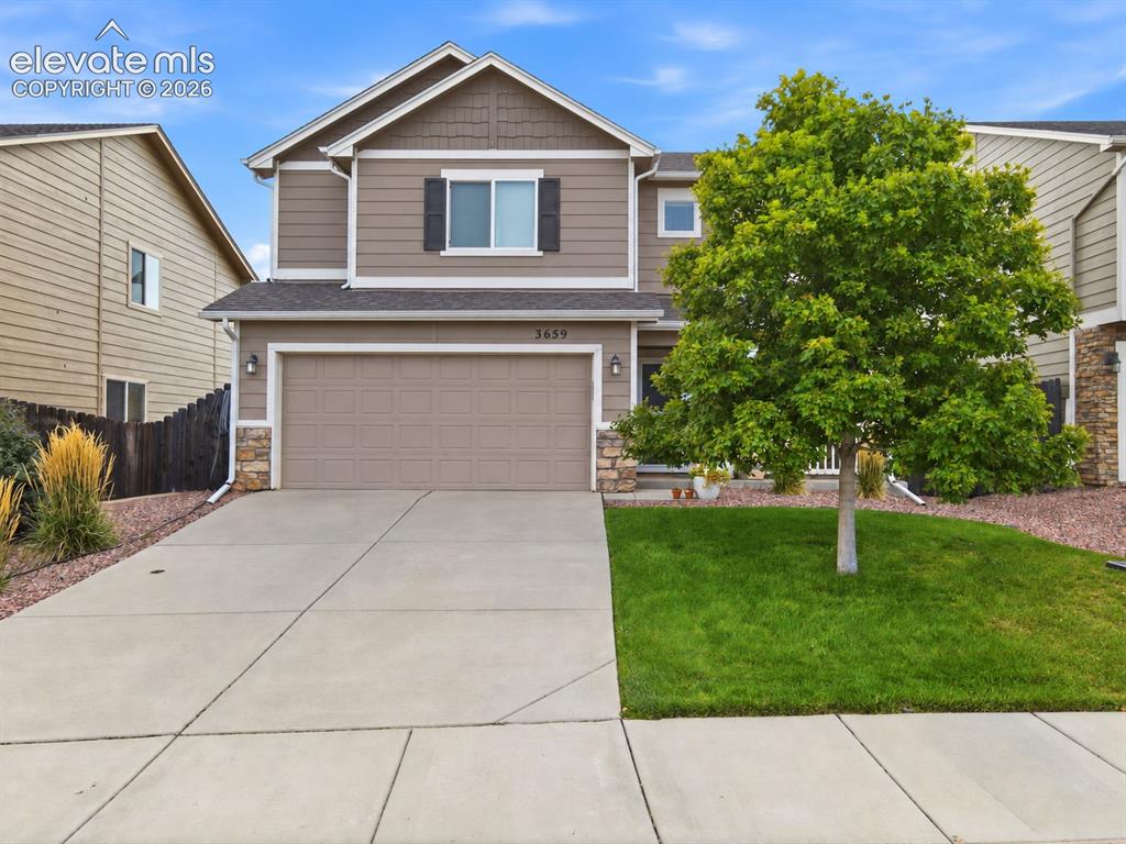 Image 2 of 48: Two-story exterior with a two-car garage and stone accents