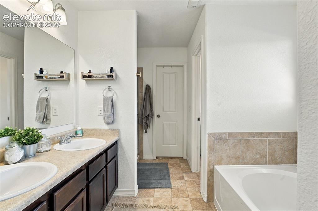 Image 27 of 48: Dual vanity with undermount sinks, laminate countertops, and dark wood-fini