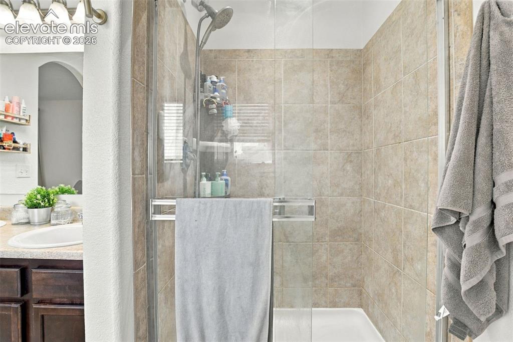 Image 29 of 48: Enclosed shower with tiled walls and a white shower pan