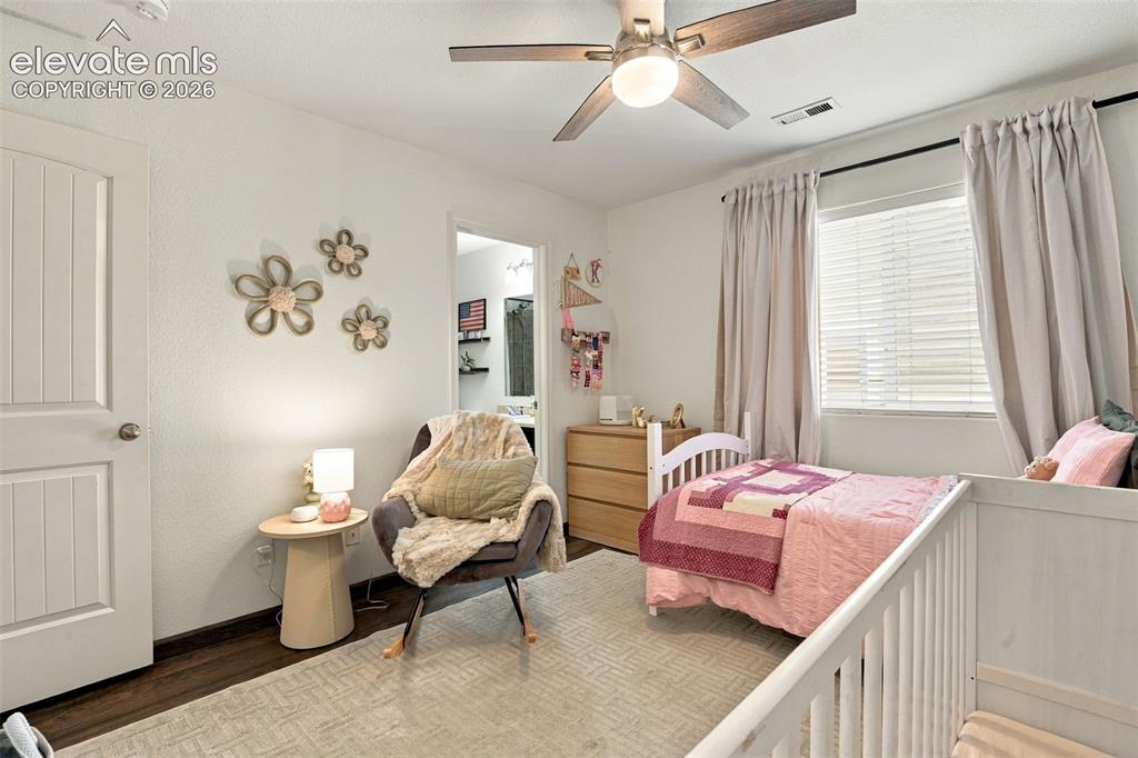 Image 35 of 48: Wood-finish flooring, white paneled door, ceiling fan with integrated light