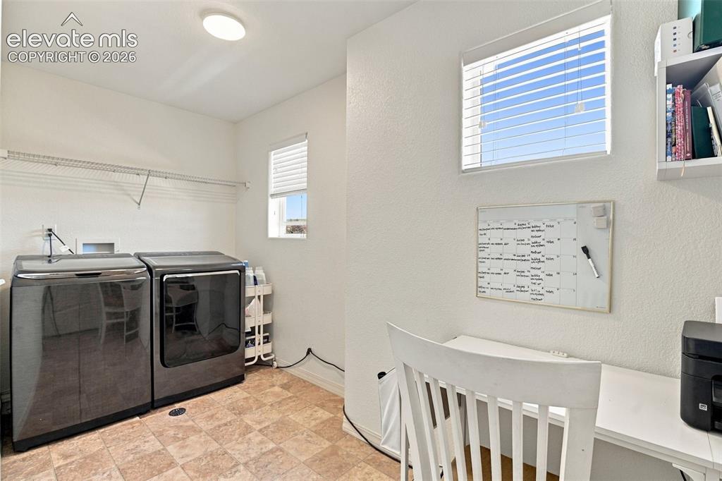 Image 36 of 48: Dedicated utility space with tiled flooring and dual windows
