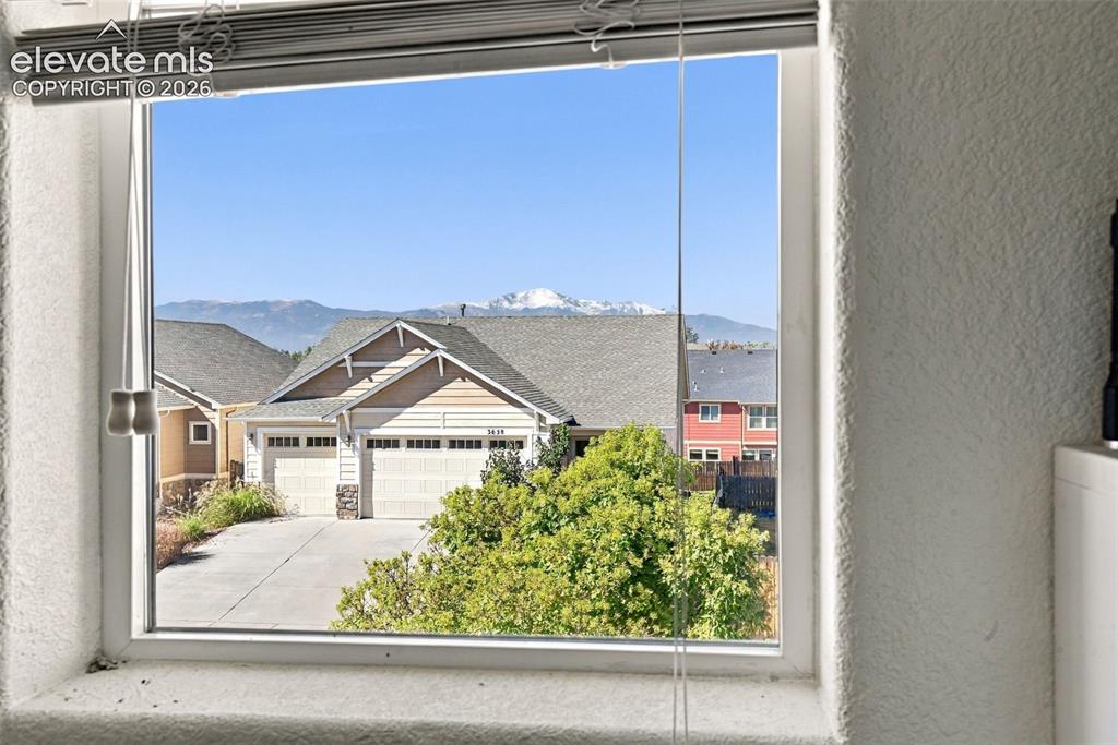Image 37 of 48: Window framing a mountain backdrop with distant snow-capped peaks