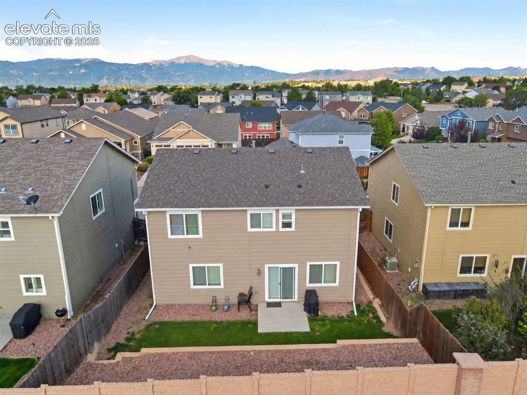 Image 45 of 48: Rear exterior featuring a patio, green lawn, and terraced landscaping