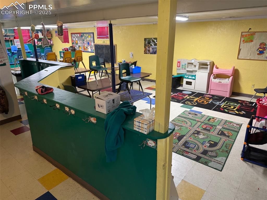 Image 21 of 33: Classroom with a textured wall and tile patterned floors