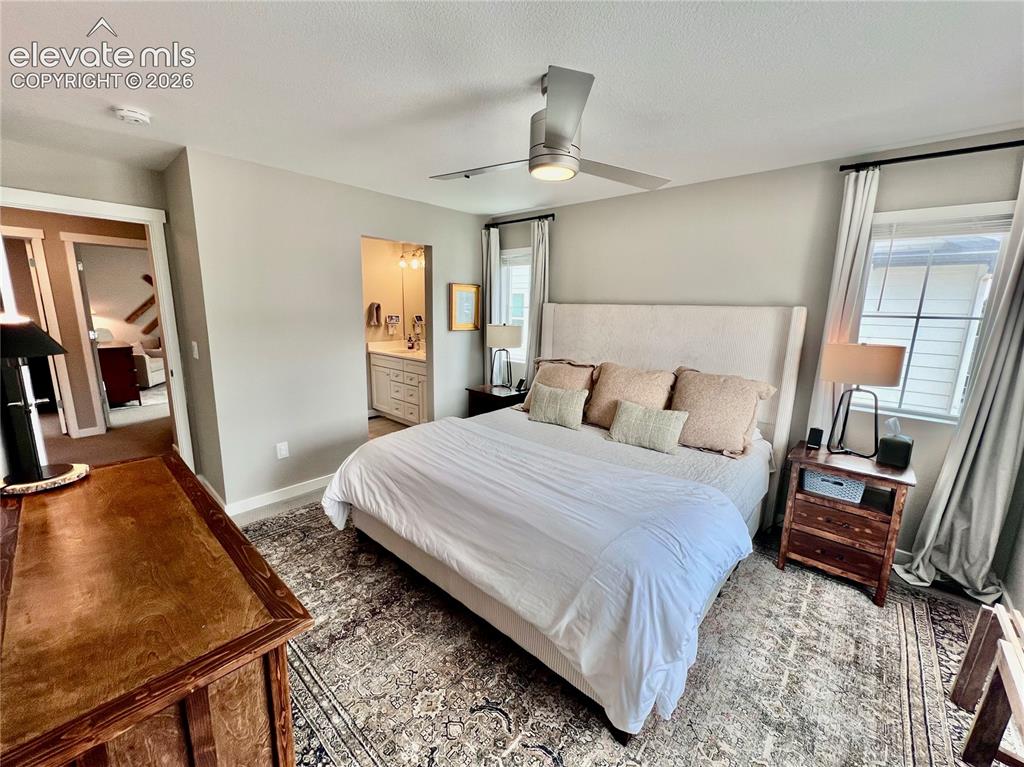Image 10 of 20: Spacious room featuring a ceiling fan, window with curtains, and an en-suit